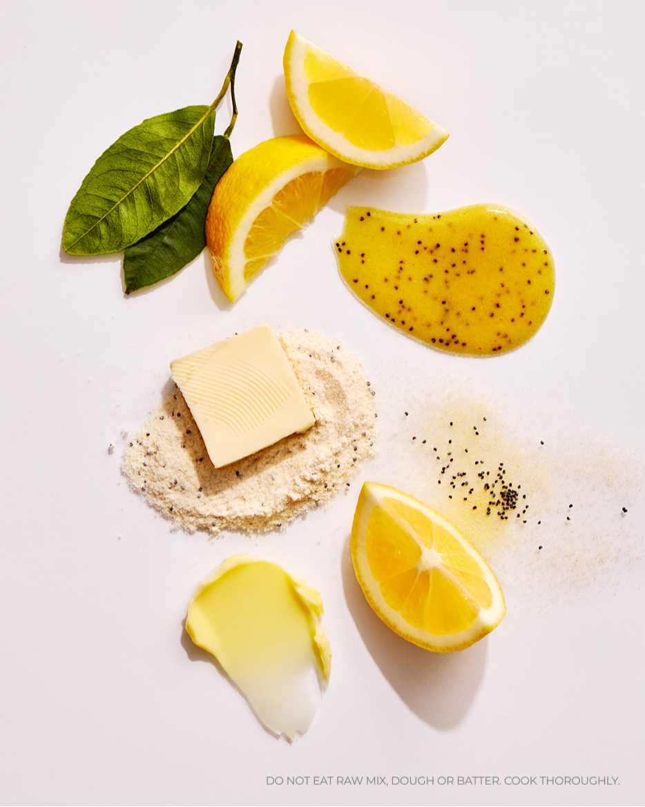 Butter, lemon slices, and Lemon Poppyseed cake mix batter on a white background