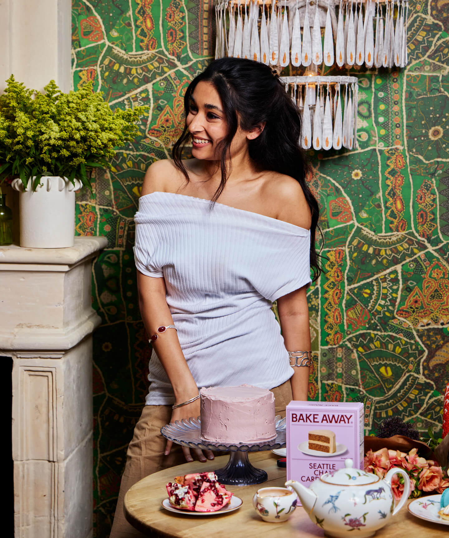 Woman in a cafe setting with a cake and decorative elements.