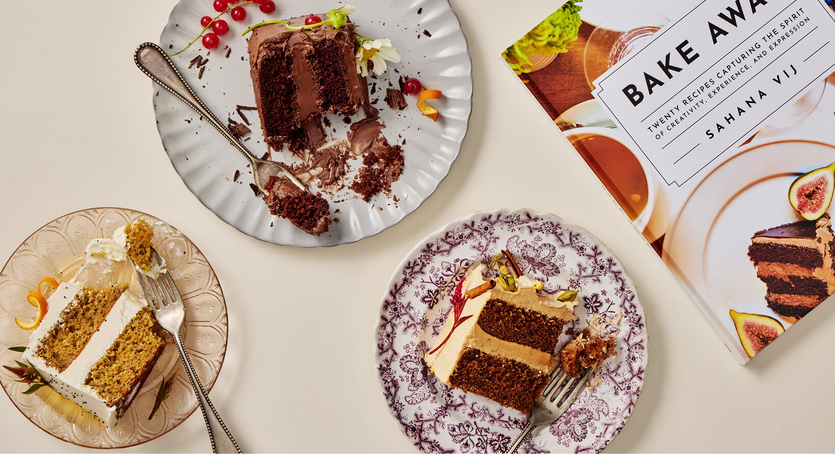 Slices of cake on plates with a cookbook titled 'Bake Away' in the background.