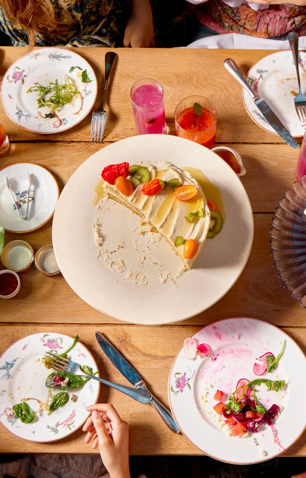 Dessert table with various plates of food and drinks on a wooden surface