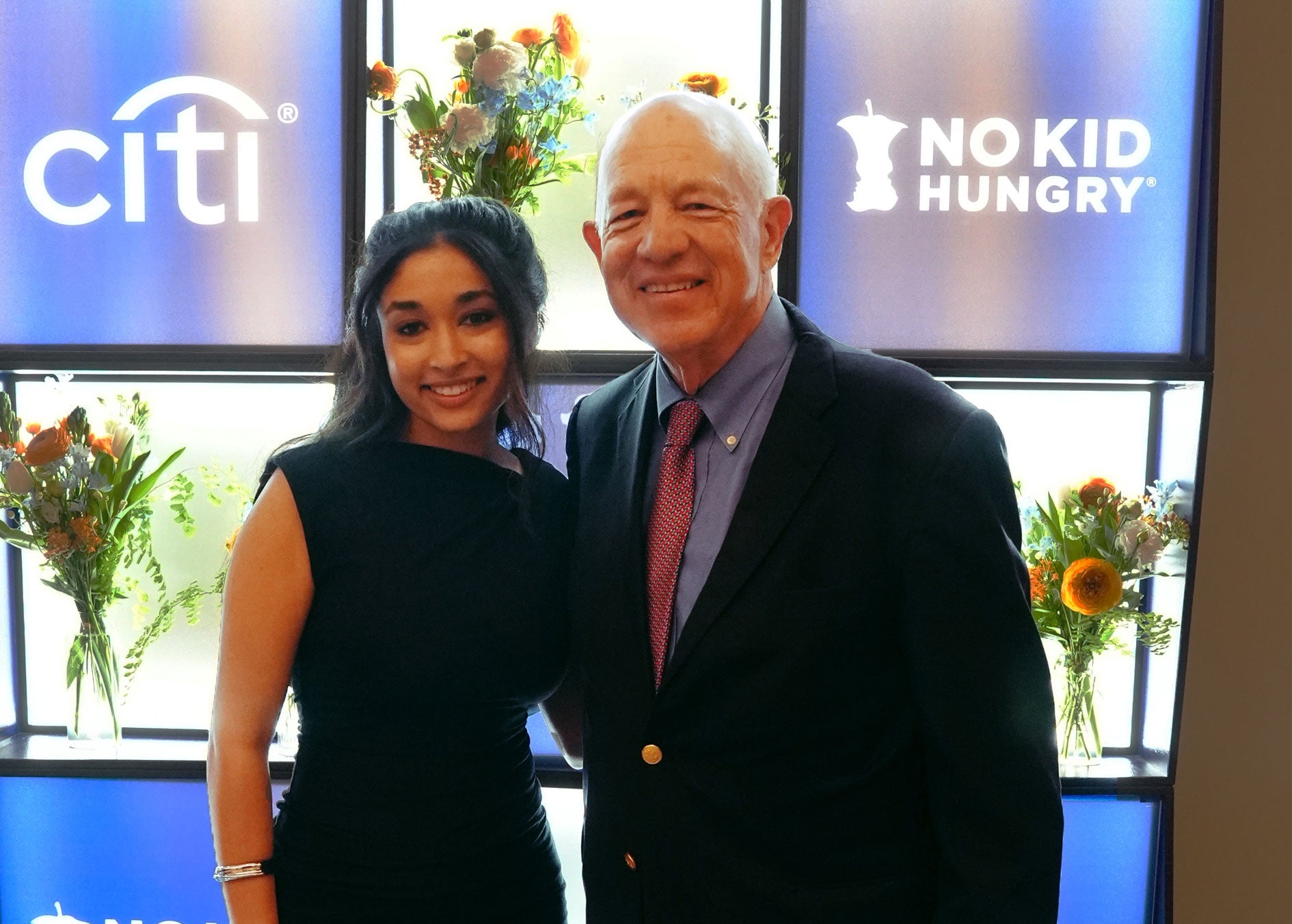 Two people posing together with Citi and No Kid Hungry logos in the background.