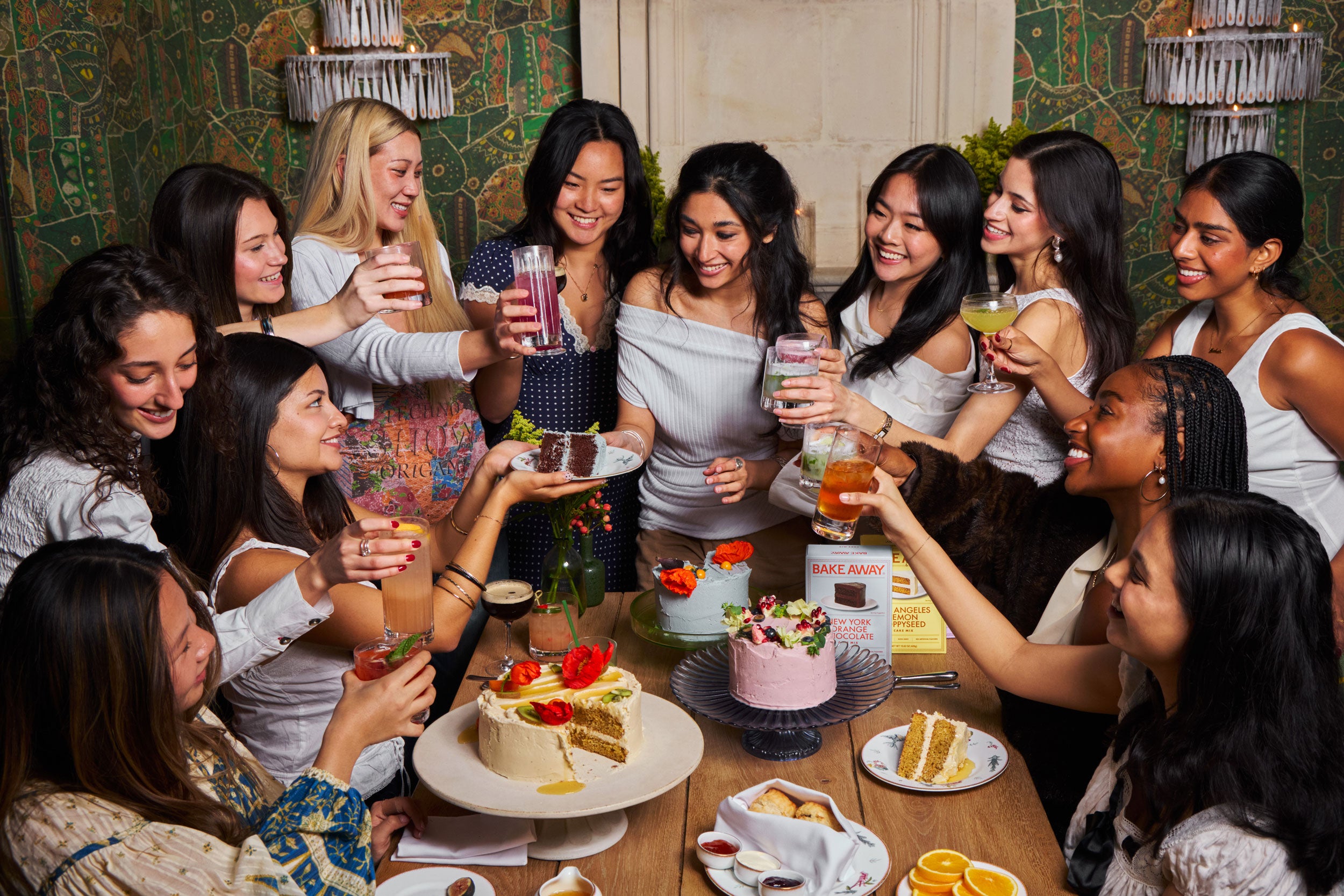 Group of women gathered around a table with desserts and drinks in a social setting.