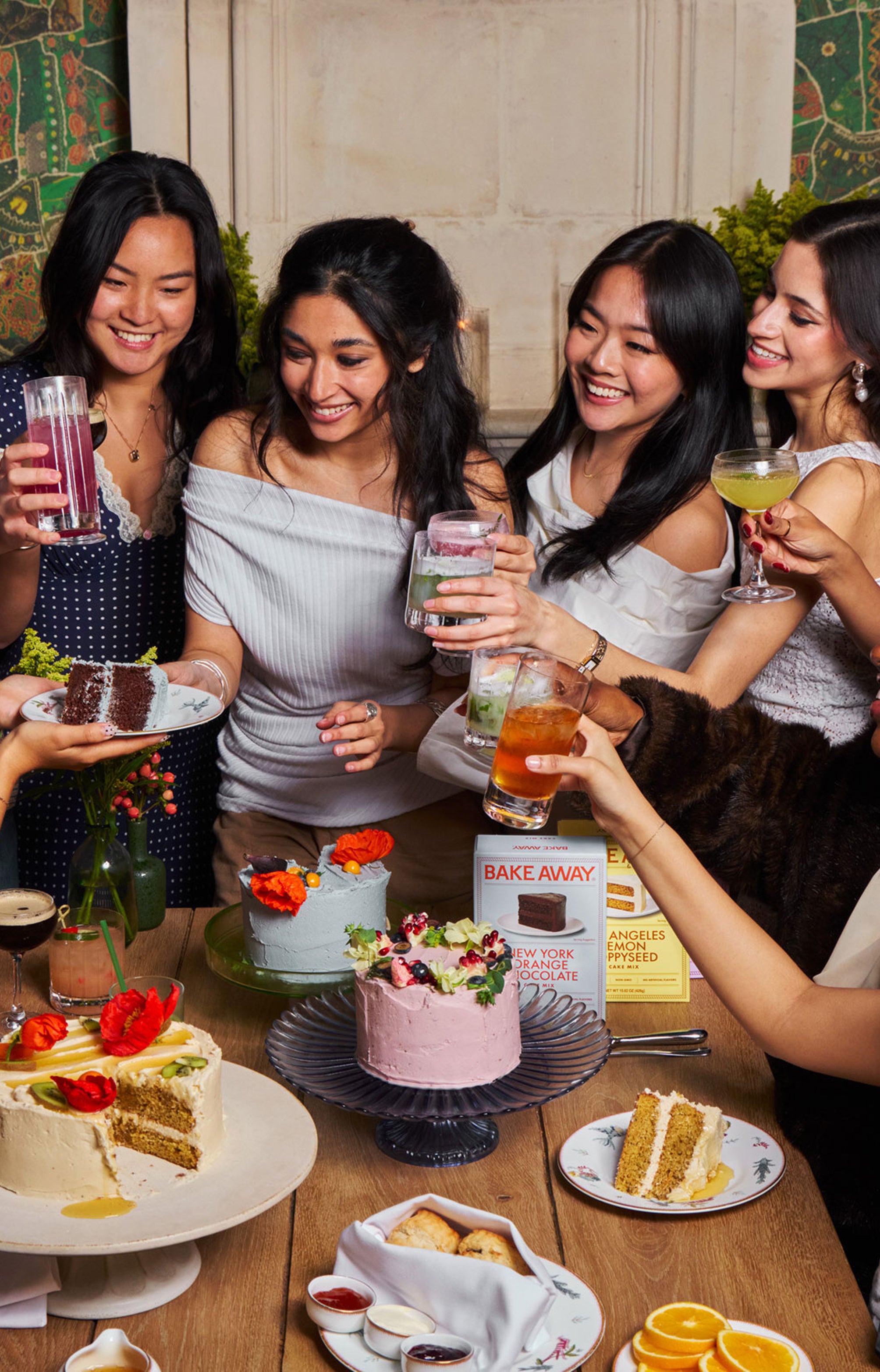 Group of women gathered around a table with desserts and drinks in a social setting.